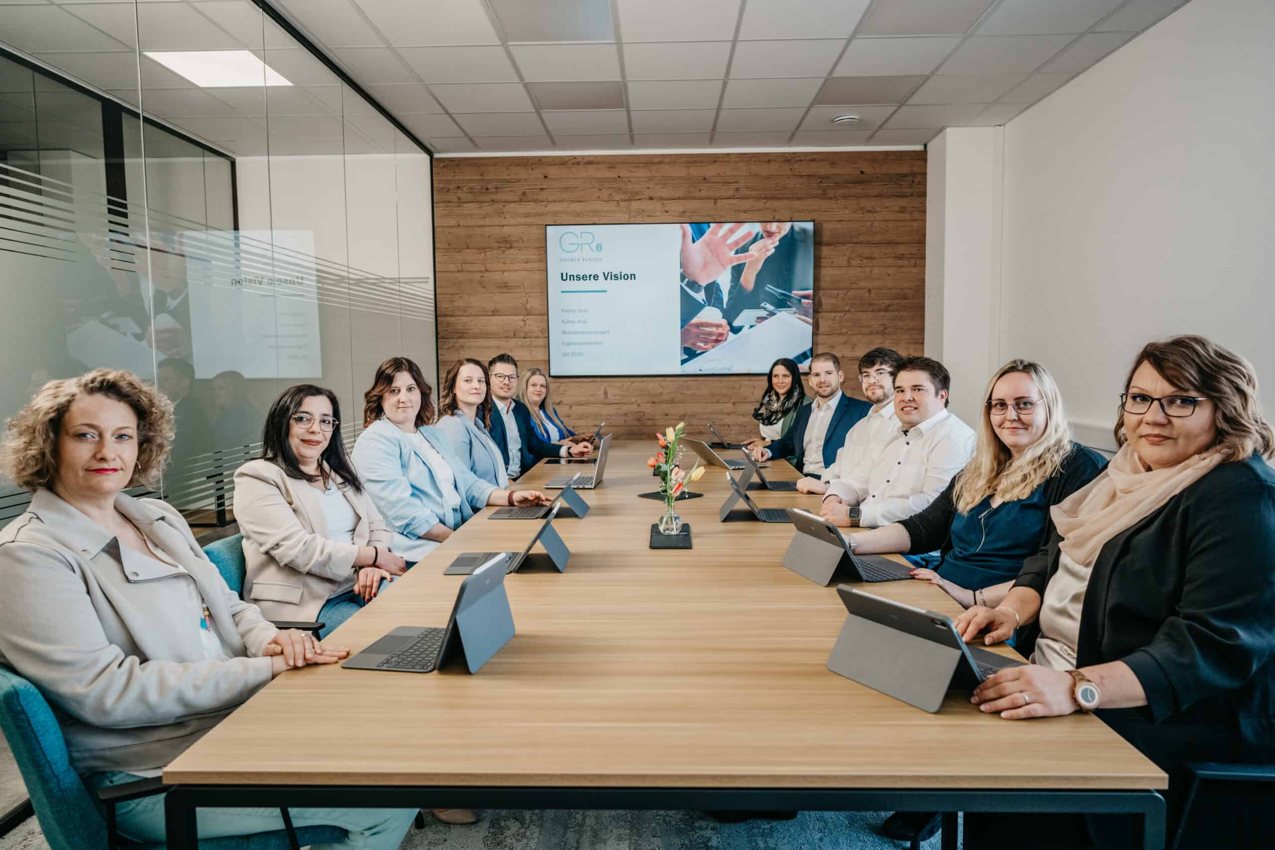 Geschäftstreffen mit 12 Personen in einem modernen Konferenzraum.