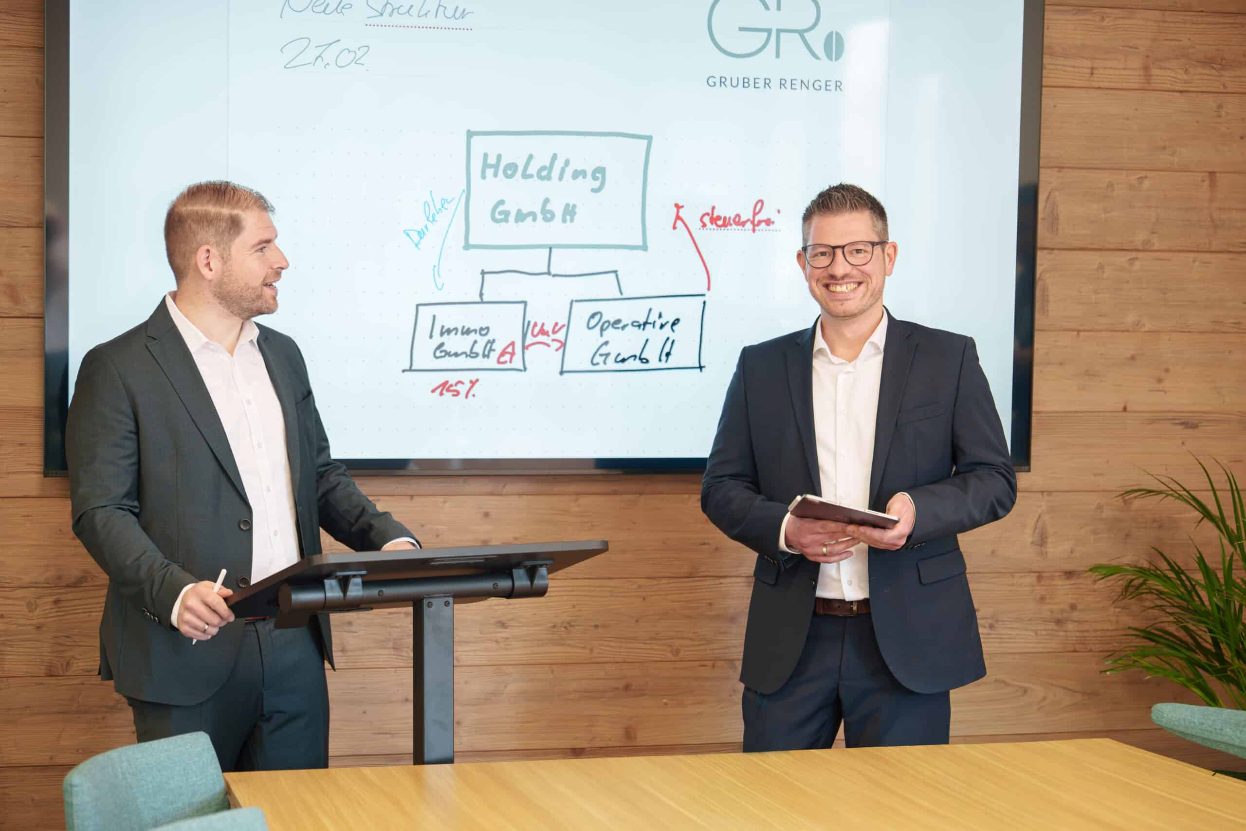 Zwei Geschäftsleute bei einer Präsentation im Konferenzraum.